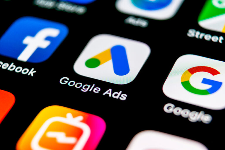 Close-up of a smartphone screen showing app icons for Facebook, Google Ads, Google, and other social/marketing apps.