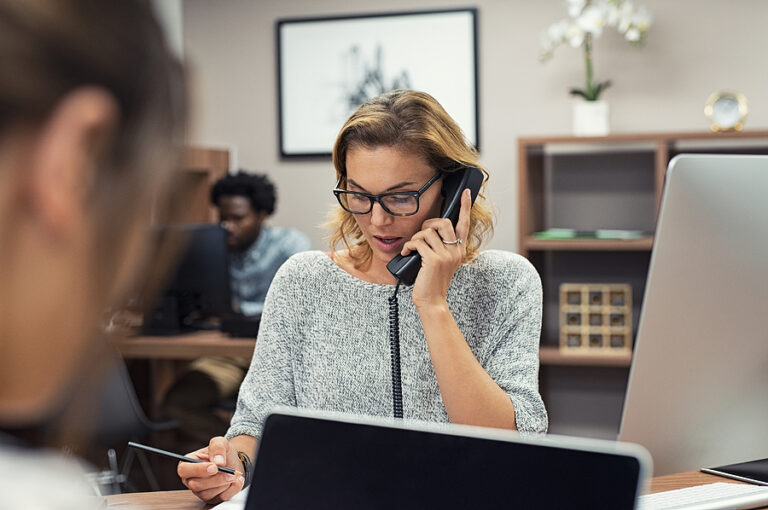 A woman is talking on the phone in an office.