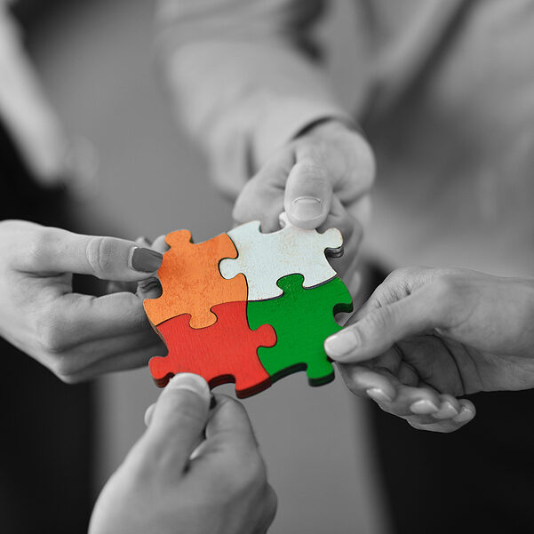 Group of business people assembling jigsaw puzzle and represent team support and help concept